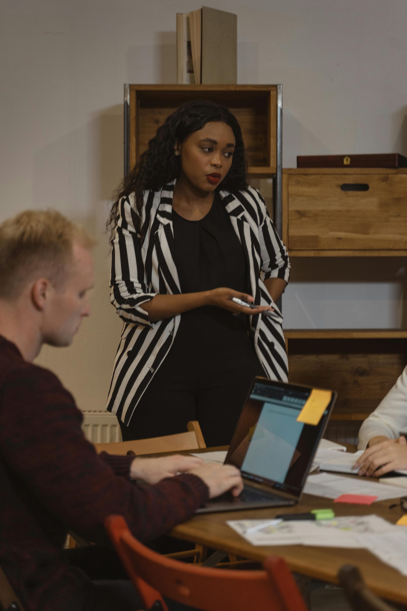 African American woman leads a discussion in a modern office with a diverse team.